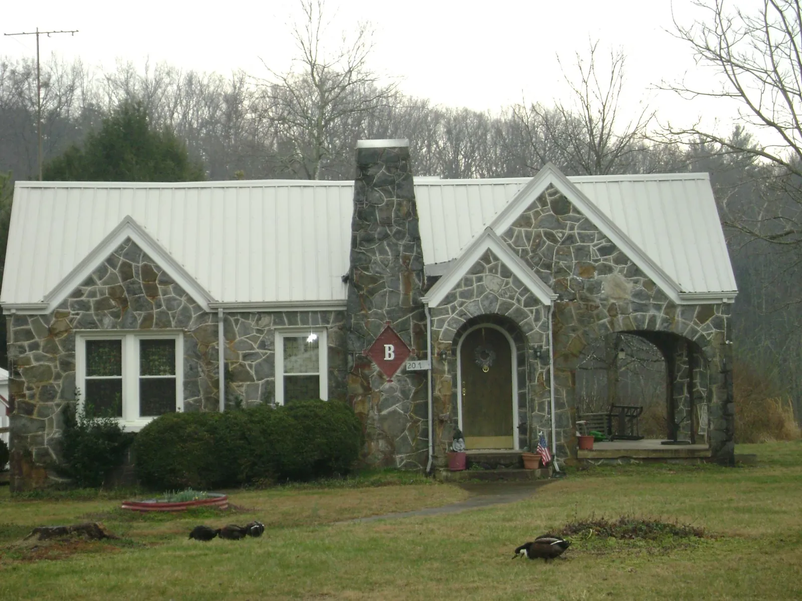 White metal roof on a stone cottage with steep gables in Milford